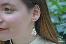 Charger l'image dans la galerie, Jeune fille portant des boucles d'oreilles en origami avec des motifs de feuilles