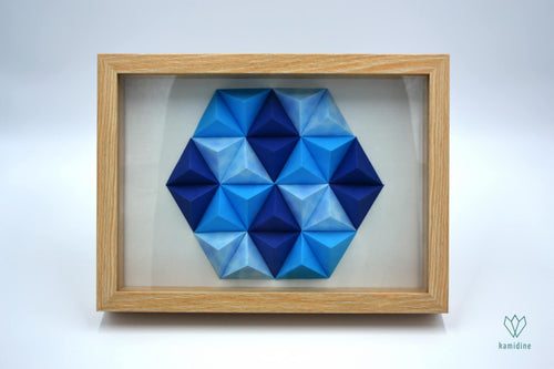 Cadre en papier origami composé de petites pyramides bleues, formant un hexagone